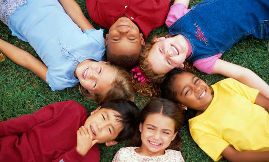 circle of kids showing their smiles