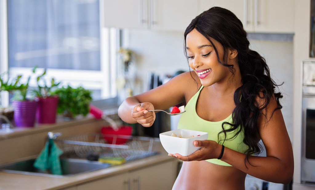 woman eating a bowl of fruits