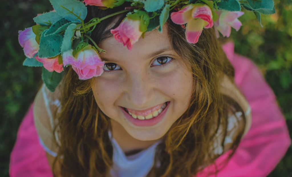 kid wearing a flower crown while smiling