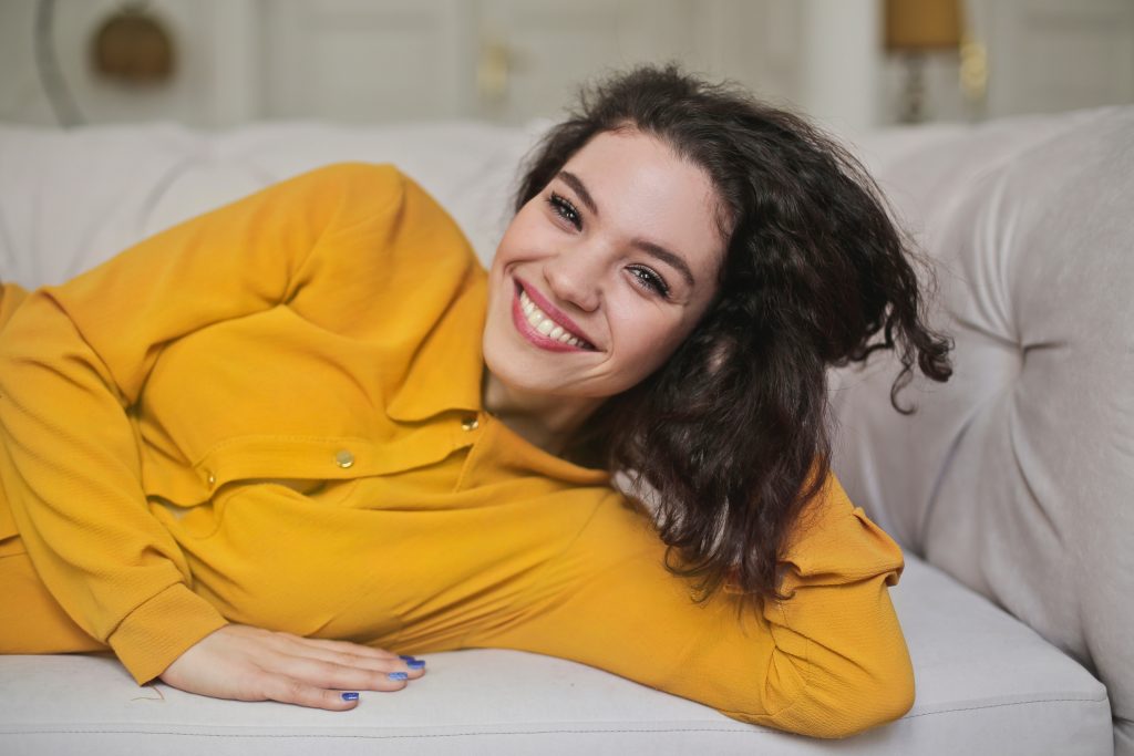 cheerful woman wearing a yellow button-up top
