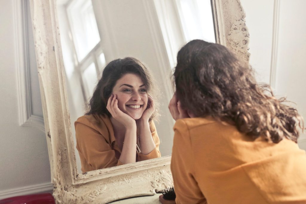 girl smiling in front of the mirror