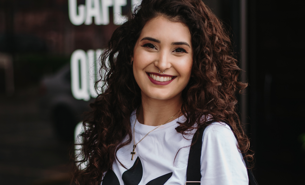 a curly-haired woman is smiling