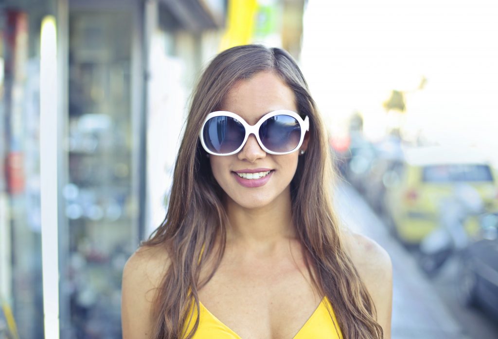 beautiful girl with a sunglasses wearing a yellow spaghetti strap