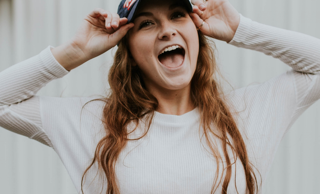 cheerful girl with a hat is wearing a white long sleeves