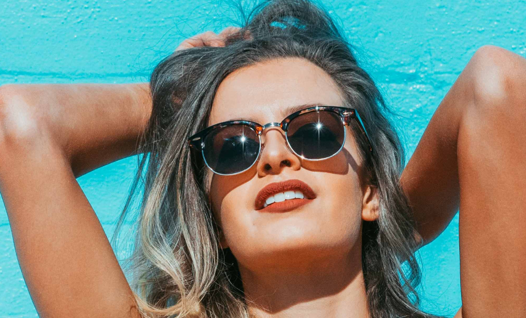 woman with maroon lipstick is wearing a sunglasses