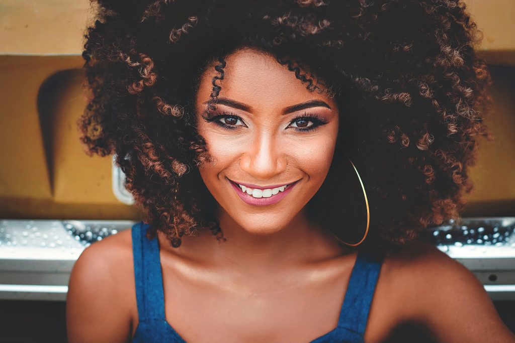 woman with curly hair wearing full makeup
