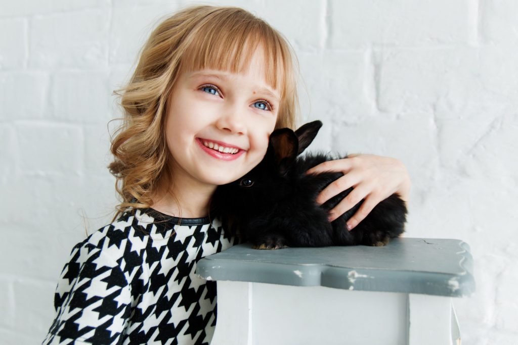 kid holding black rabbit