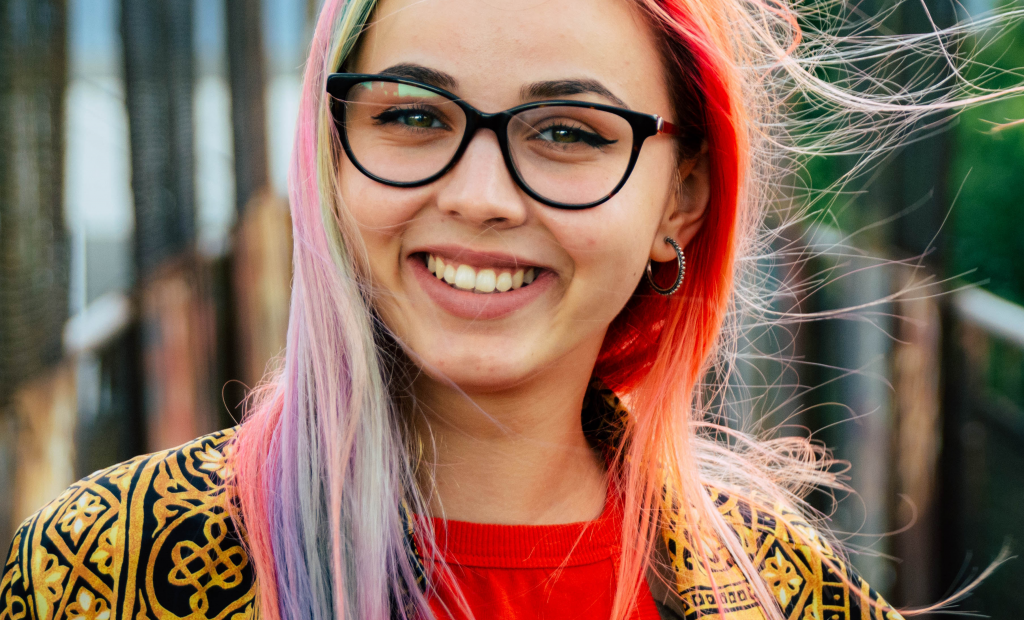 woman with a colourful hair is wearing an eyeglasses