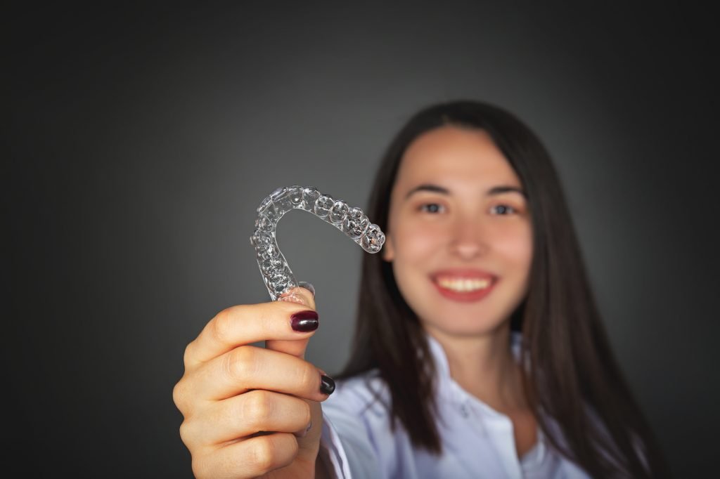 girl holding a clear invisalign