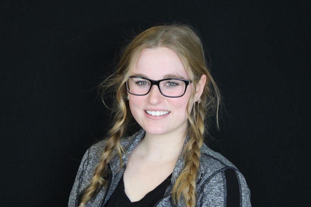 pretty girl with black eyeglasses showing her teeth after braces